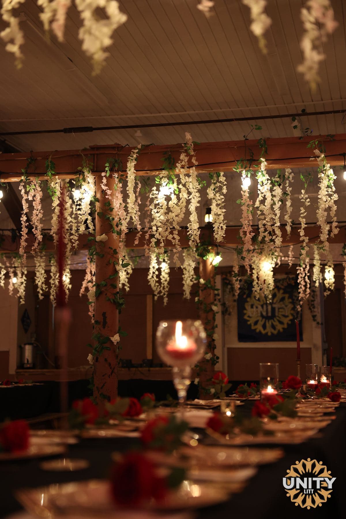 Flowers and strings of small lights hung across a ceiling above the tables