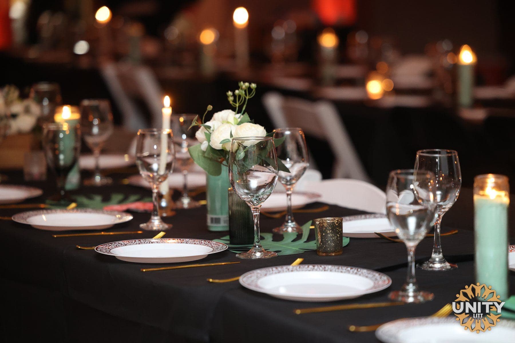A long table laid for a festive meal, candles lit down the centre
