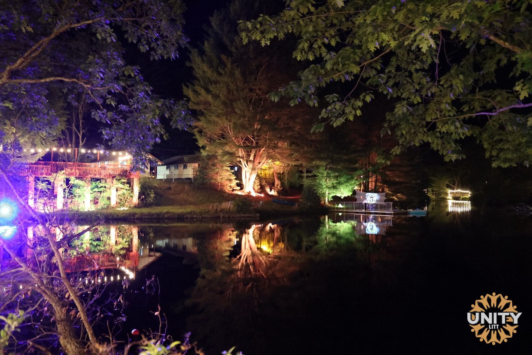 The lake at night, lights from the property reflected across the water