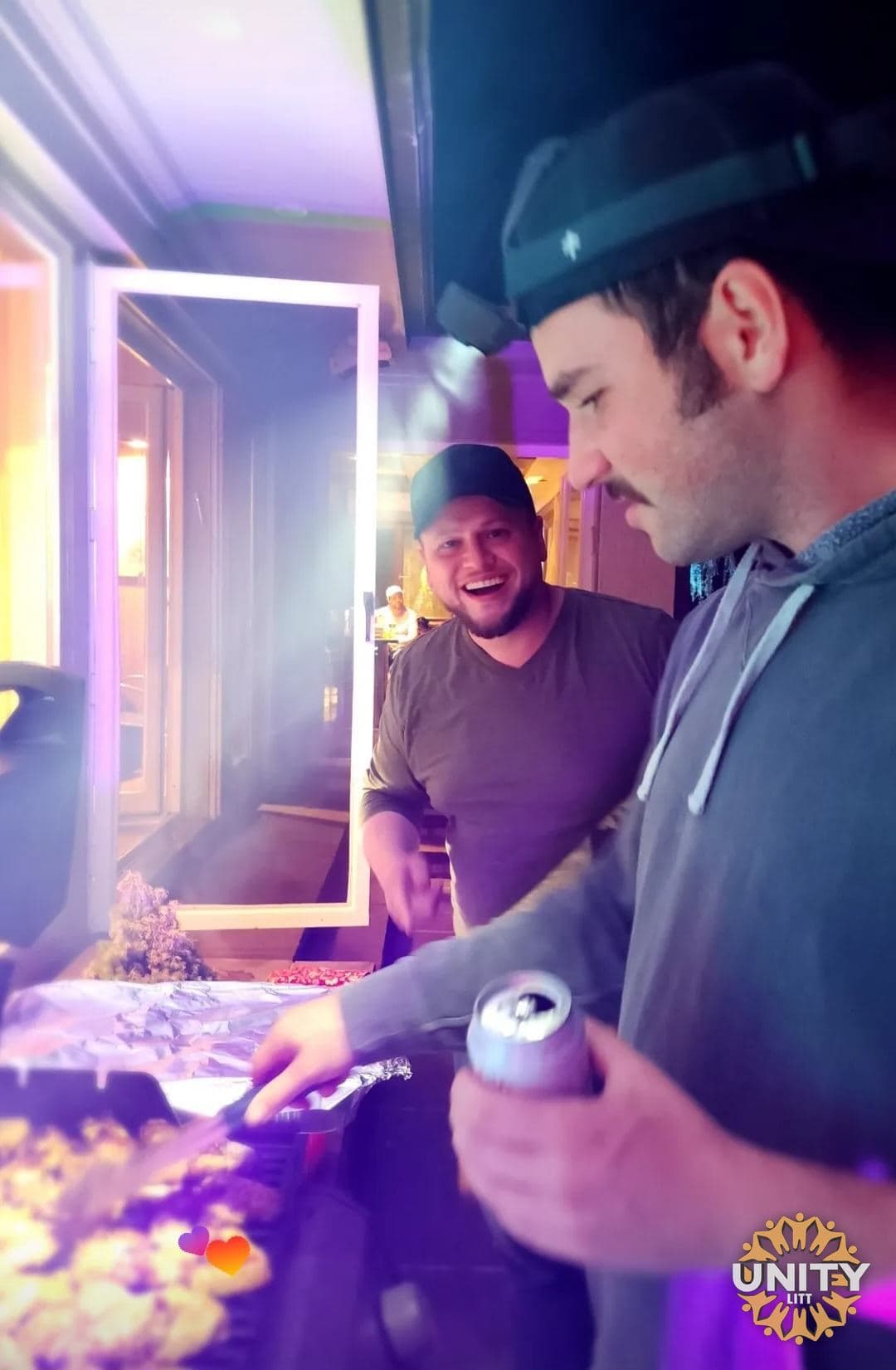Two men pouring drinks at the table, mid-conversation