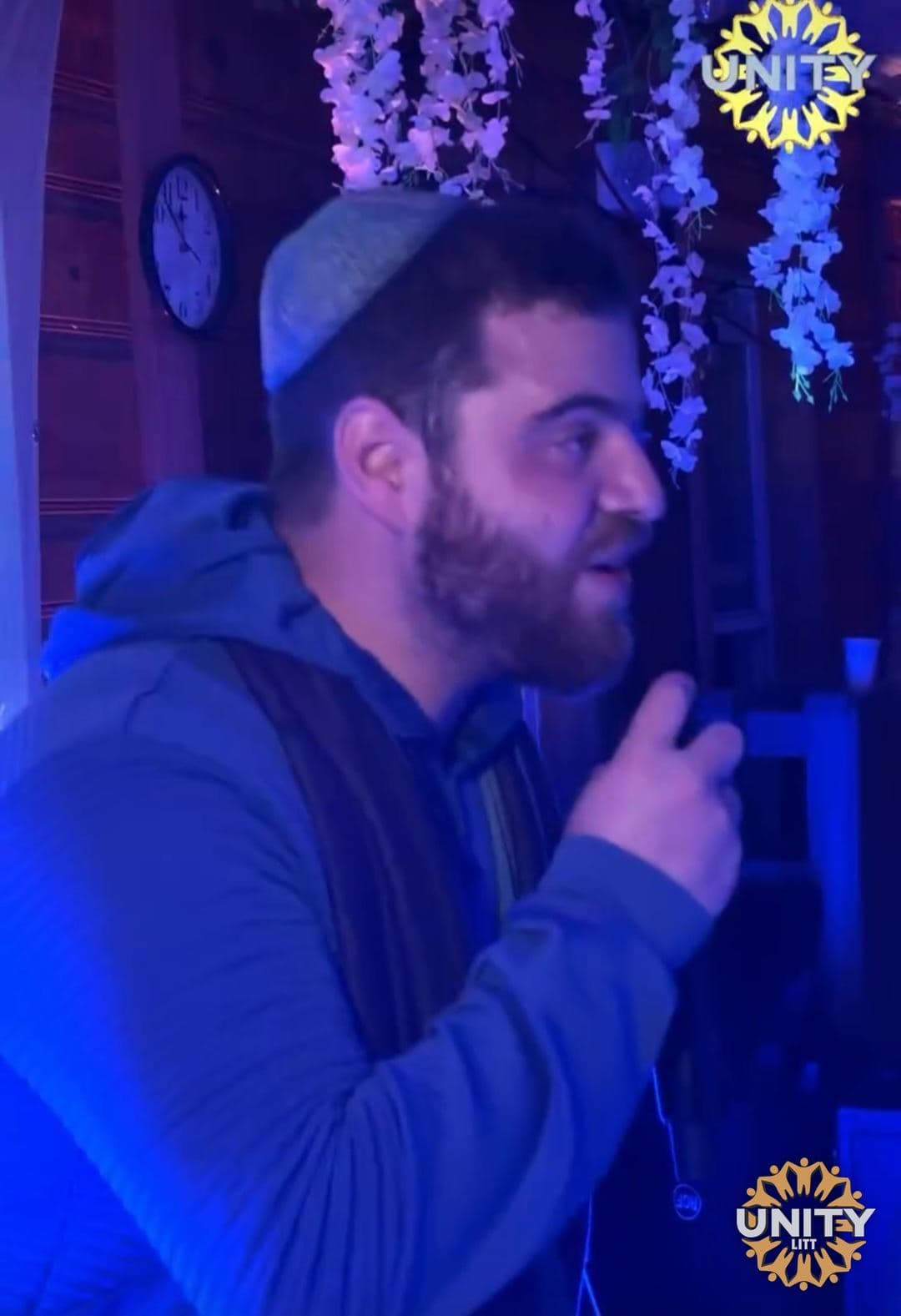 A singer in blue stage light, mid-phrase